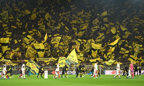 Dortmund fans wave their flags as the players arrive on the pitch.