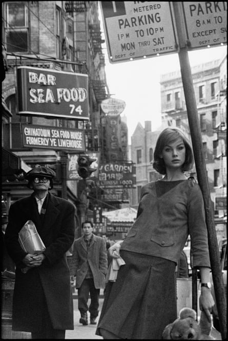 Black and white photo of model Jean Shrimpton, teddy bear in one hand, on the streets of New York, 1962